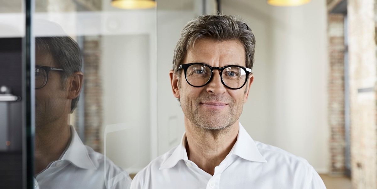 man with glasses smiling in office