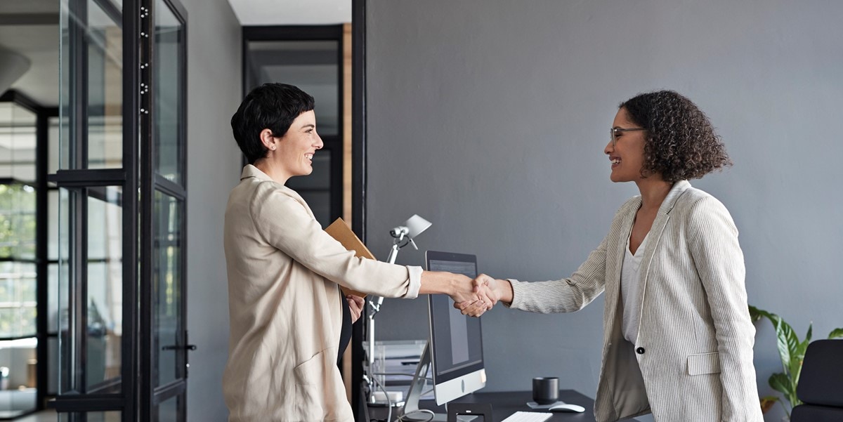 two professional women in the office, shaking hands